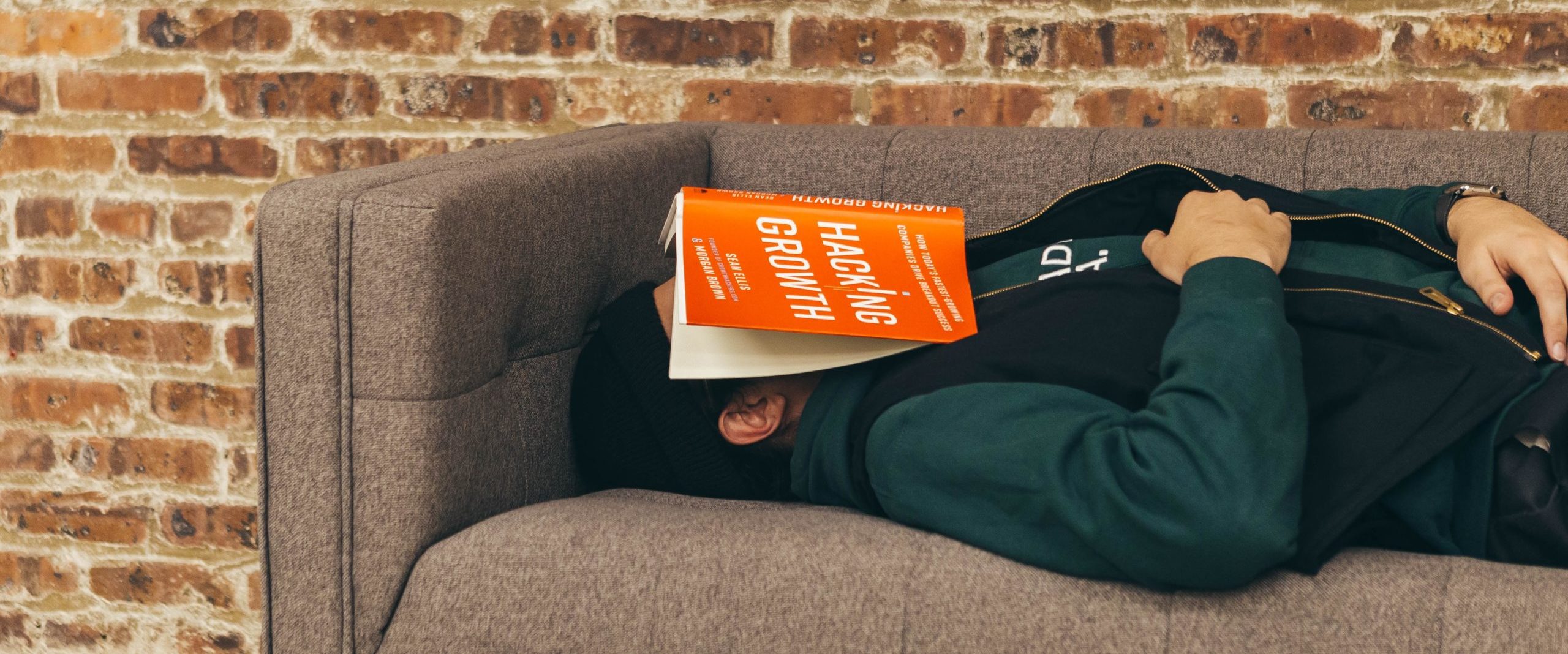 person sleeping on sofa near the wall