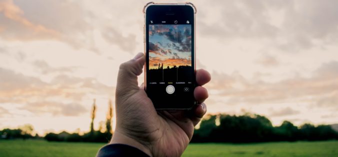 person taking photo using iPhone